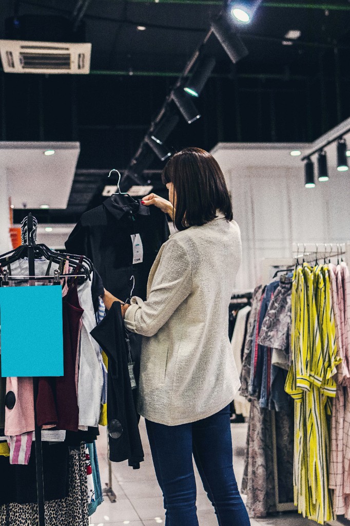 Shopper inspecting a garment on the rack in a clothing retail store